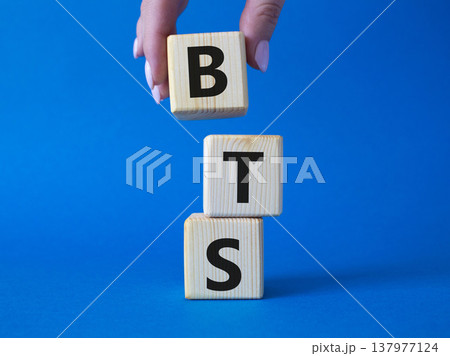 BTS symbol. Wooden cubes with word BTS. Businessman hand Beautiful blue background. BTS concept. Copy space. 137977124