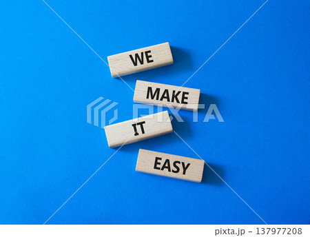 We Make it Easy symbol. Concept words We Make it Easy on wooden blocks. Beautiful bright blue background. Business and We Make it Easy concept. Copy space. 137977208