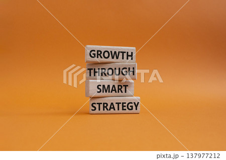 Smart strategy symbol. Wooden blocks with words Growth through smart strategy. Beautiful orange background. Business and Smart strategy concept. Copy space 137977212