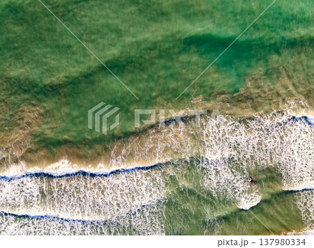 Top view waves crashing on beach background Top view waves crashing on beach background 137980334