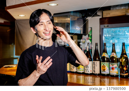 居酒屋で働く男性 スマホ 居酒屋で働く男性 スマホ 137980500