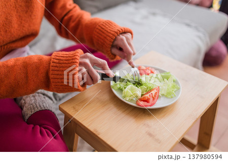 Woman cutting salad showing eating disorder concept Woman cutting salad showing eating disorder concept 137980594