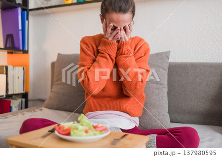 Woman struggling with eating disorder showing distress about food Woman struggling with eating disorder showing distress about food 137980595