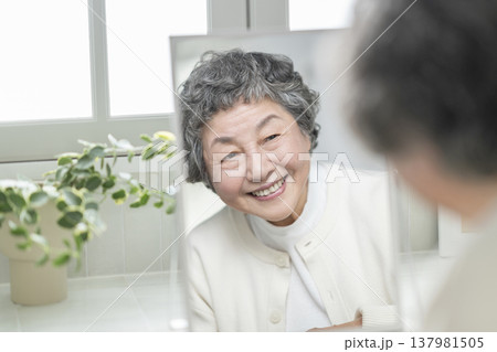 鏡を見ながら微笑む80代の女性　スキンケア・ビューティ　イメージ 137981505