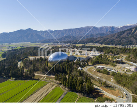 残雪の山々と福井県立恐竜博物館のドーム 晴天のドローン空撮 137983092