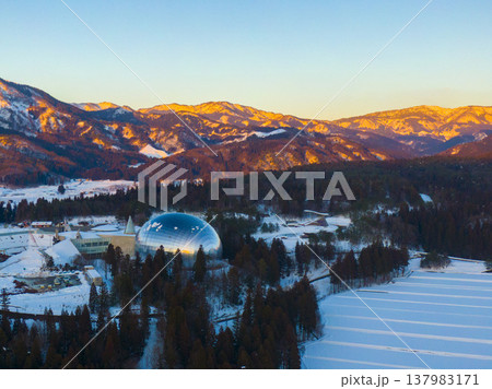 夕陽に染まる雪山と福井県立恐竜博物館 ドローンによる冬の空撮 137983171