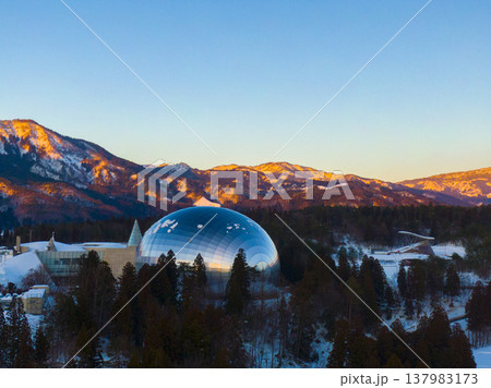 夕陽に染まる雪山と福井県立恐竜博物館 ドローンによる冬の空撮 夕陽に染まる雪山と福井県立恐竜博物館 ドローンによる冬の空撮 137983173