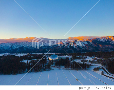 夕陽に染まる雪山と福井県立恐竜博物館 ドローンによる冬の空撮 夕陽に染まる雪山と福井県立恐竜博物館 ドローンによる冬の空撮 137983175