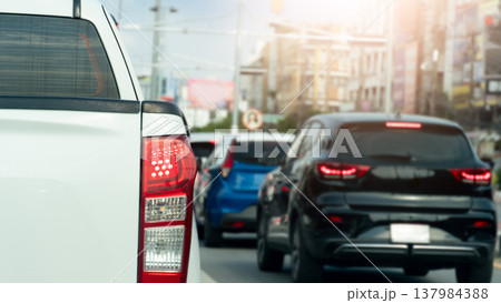 Rear side of pikup white car with turn on brake light. Traffic jam on the asphalt road with many car in the city. Background blurred of town in Rayong Thailand. Rear side of pikup white car with turn on brake light. Traffic jam on the asphalt road with many car in the city. Background blurred of town in Rayong Thailand. 137984388
