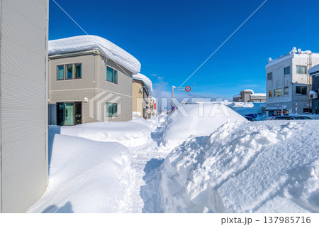 雪国の生活：豪雪の中の久しぶりの晴天。歩道はひとりやっと通れるほどに狭くなっているがきれいな風景 137985716