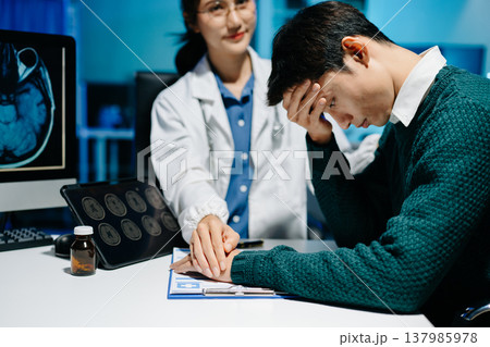Female doctor comforting stressed male patient during medical consultation. Brain MRI scan, mental health diagnosis, healthcare support and modern medical technology. Female doctor comforting stressed male patient during medical consultation. Brain MRI scan, mental health diagnosis, healthcare support and modern medical technology. 137985978