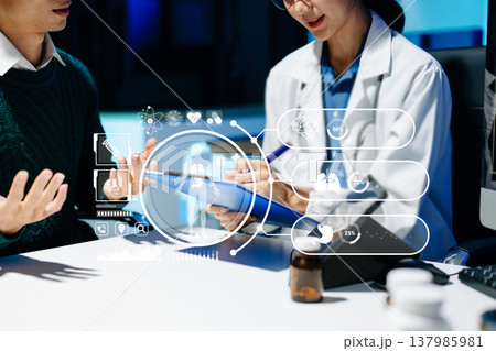 Doctor explains medical form as patient signs consent in modern clinic. Healthcare, insurance, medical consultation, diagnosis, treatment, documentation concept. 137985981