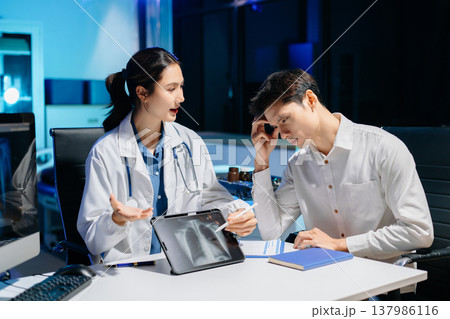Asian doctor comforting stressed patient in hospital office, showing compassion, empathy, and emotional support during mental health consultation. Asian doctor comforting stressed patient in hospital office, showing compassion, empathy, and emotional support during mental health consultation. 137986116