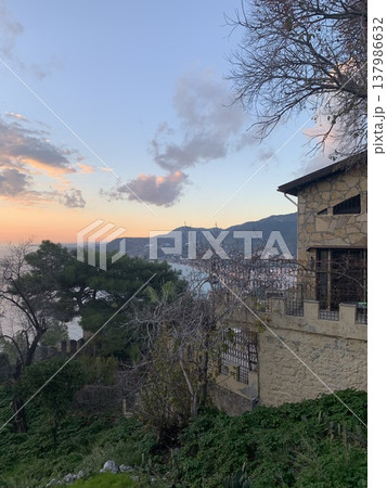 Scenic coastal view with stone house and mountains at sunset Scenic coastal view with stone house and mountains at sunset 137986632