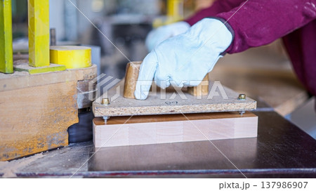 Carpenter cutting wood plank using spindler machine in workshop Carpenter cutting wood plank using spindler machine in workshop 137986907