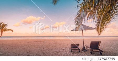Romantic panoramic sunset beach with couple, sun beds and umbrellas, serene leisure lifestyle, honeymoon tropical getaway, dreamy summer travel background Romantic panoramic sunset beach with couple, sun beds and umbrellas, serene leisure lifestyle, honeymoon tropical getaway, dreamy summer travel background 137987749