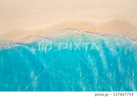Breathtaking aerial summer beach with turquoise ocean waves and pristine sandy shore, radiant sunlight over calm sea, idyllic tropical paradise travel background Breathtaking aerial summer beach with turquoise ocean waves and pristine sandy shore, radiant sunlight over calm sea, idyllic tropical paradise travel background 137987754