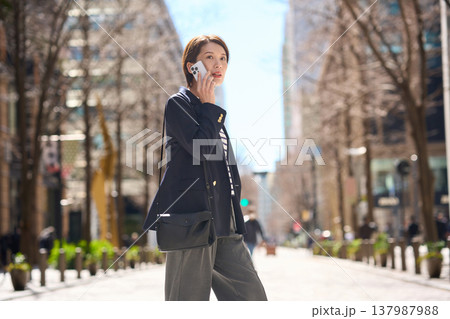 街を歩きながらスマートフォンで通話する30代日本人ビジネスウーマン 街を歩きながらスマートフォンで通話する30代日本人ビジネスウーマン 137987988