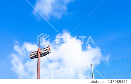 爽やかな青空と白い雲と競技場の照明のあるシンプルな風景 爽やかな青空と白い雲と競技場の照明のあるシンプルな風景 137989823