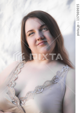 Portrait of a happy young woman against a wall. Body positivity. Vertical photo 137989935