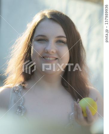Body positivity. Portrait of a happy young woman against a wall. Vertical photo Body positivity. Portrait of a happy young woman against a wall. Vertical photo 137989936