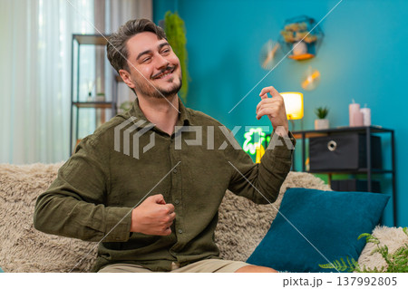 Middle-aged man strumming air guitar energetic riff lively playful moves enjoying rock rhythm vibe 137992805