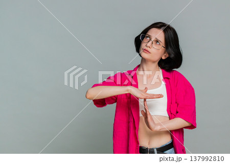 Young woman showing timeout gesture with hands seriously asking for pause break stop communication Young woman showing timeout gesture with hands seriously asking for pause break stop communication 137992810
