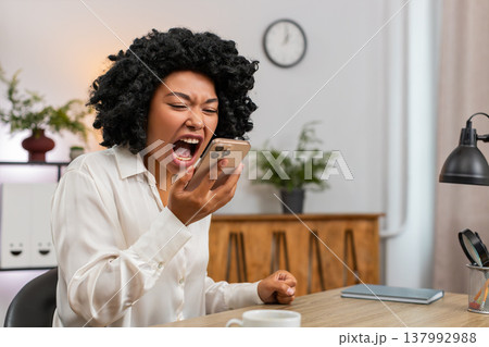 African American businesswoman argues loudly on smartphone upset by dispute during tense phone call African American businesswoman argues loudly on smartphone upset by dispute during tense phone call 137992988