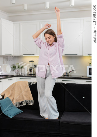 Young woman dances jumps to loud music enjoys party energy carefree joyful freedom and playful moves 137993050