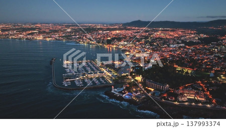 Portugal, Lisbon: Breathtaking aerial view of Cascais city harbour at sunset, highlighting the illuminated cityscape night lights, vibrant marina, and tranquil Atlantic coastline. Drone Portugal, Lisbon: Breathtaking aerial view of Cascais city harbour at sunset, highlighting the illuminated cityscape night lights, vibrant marina, and tranquil Atlantic coastline. Drone 137993374