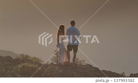 Lovely couple admiring stunning mountain sunset from a Tenerife mountaintop, celebrating love and enjoying nature tranquility on vacation travel holiday trip. Drone flight aerial panorama 137993382