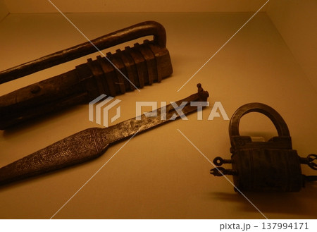 Vintage metal padlock and key on a plain background, showcasing traditional Indian craftsmanship from Rajasthan. Vintage metal padlock and key on a plain background, showcasing traditional Indian craftsmanship from Rajasthan. 137994171