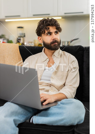 Indian man freelance worker with laptop typing focused remote job online planning ideas project work 137994263