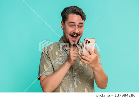 Man laughing at smartphone watching funny memes online videos with joyful emotion positive reaction Man laughing at smartphone watching funny memes online videos with joyful emotion positive reaction 137994296