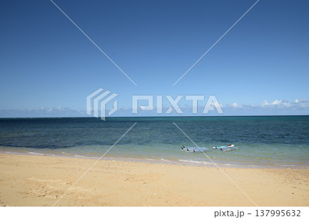 晴れ渡る青い空と白い砂浜と青い海に浮いているカヌー 137995632