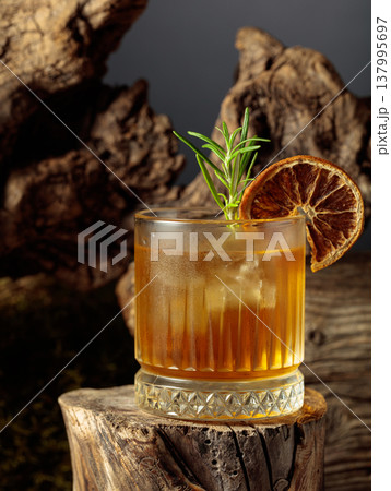 Old-fashioned cocktail with ice on an old wooden stump. 137995697