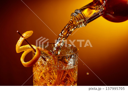 Whiskey or bourbon pouring into a crystal glass. 137995705