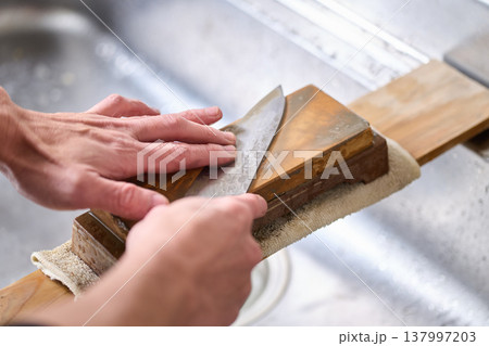 包丁を研ぐ男性 137997203