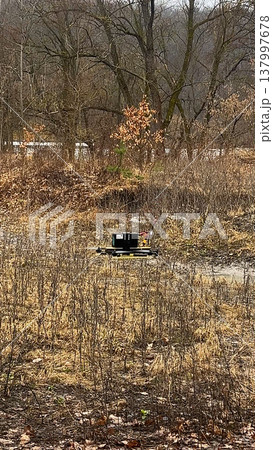 The FPV drone flies at low altitude along a path in the forest  137997678