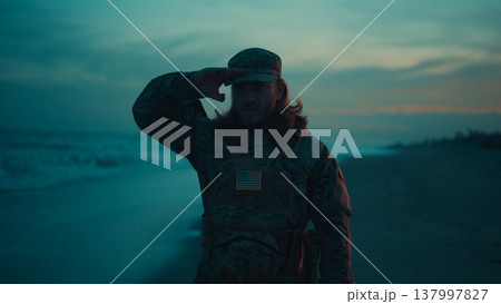 Silhouette of an American soldier saluting near the stormy ocean At Memorial Day Silhouette of an American soldier saluting near the stormy ocean At Memorial Day 137997827