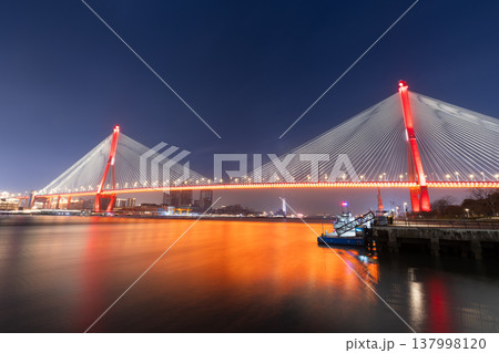 上海楊浦大橋の夜景、赤いライトアップと黄浦江オレンジ色の水面反射長時間露光 137998120