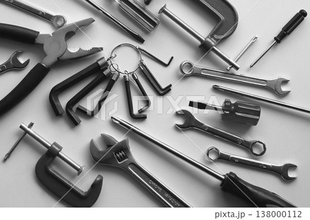 Variety scattered hand tools on a white shelf. Monochrome stock photo for repairing backgrounds Variety scattered hand tools on a white shelf. Monochrome stock photo for repairing backgrounds 138000112