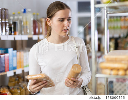 Female shopper chooses tasty cookies in supermarket Female shopper chooses tasty cookies in supermarket 138000526