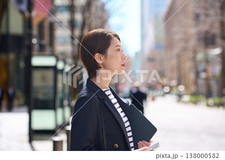 街を歩く紺ブレスタイルの30代日本人ビジネスウーマン 街を歩く紺ブレスタイルの30代日本人ビジネスウーマン 138000582