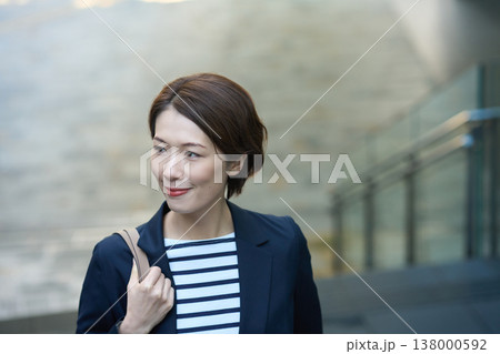 街を歩く紺ブレスタイルの30代日本人ビジネスウーマン 街を歩く紺ブレスタイルの30代日本人ビジネスウーマン 138000592