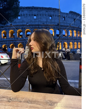 Evening at Colosseum Italy young woman enjoying Aperol with strawberries clinking glasses relaxing lifestyle travel luxury urban 138000970
