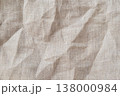 High quality horizontal shot of natural beige linen fabric with classic herringbone weave pattern. The surface features elegant organic wrinkles and soft shadows creating a sophisticated tactile feel 138000984