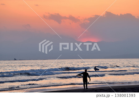 夕焼けに染まる鵠沼海岸から上がるサーファー 138001393