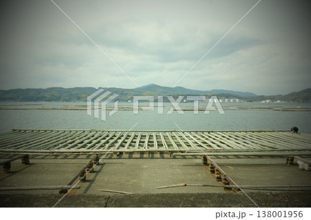 穏やかな海に広がる牡蠣養殖棚と山並みの風景 穏やかな海に広がる牡蠣養殖棚と山並みの風景 138001956