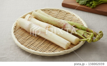 竹製のざるに置かれた瑞々しい独活が、春の訪れを告げる香り高い旬の食材として食卓を明るく彩ります。 竹製のざるに置かれた瑞々しい独活が、春の訪れを告げる香り高い旬の食材として食卓を明るく彩ります。 138002039